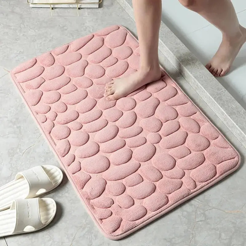 Alfombra de baño rosa con patrón de piedritas en colección Baño