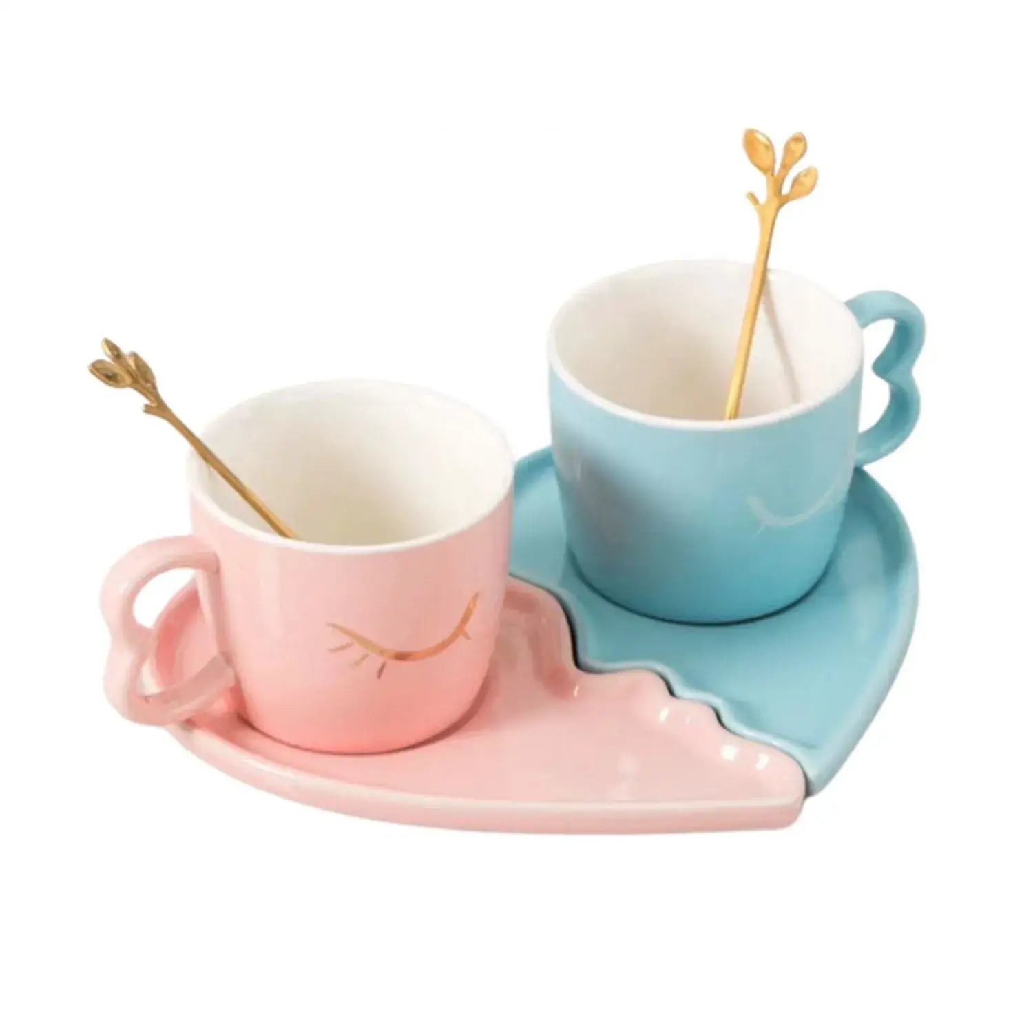 Tazas de café cerámicas en rosa pastel y azul con diseños de hoja de oro, en platos en forma de corazón de la colección VARIOS.